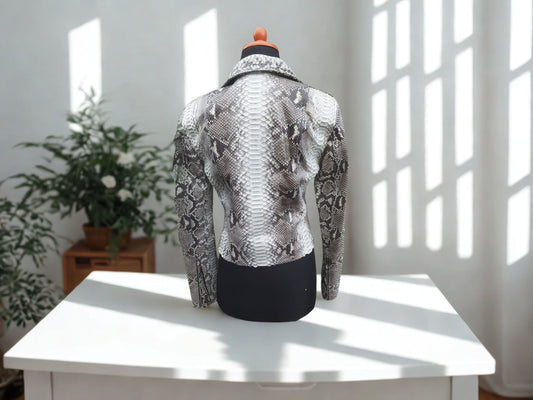 Mannequin wearing a snakeskin jacket on a white table with a light background